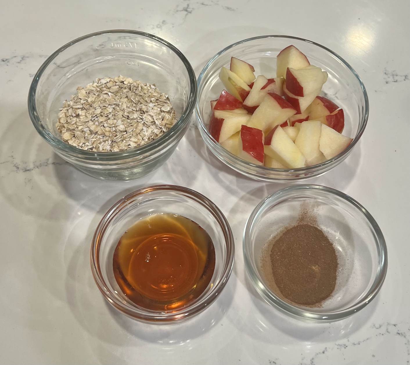 sliced apples, honey, cinnamon, and oats in glass bowls